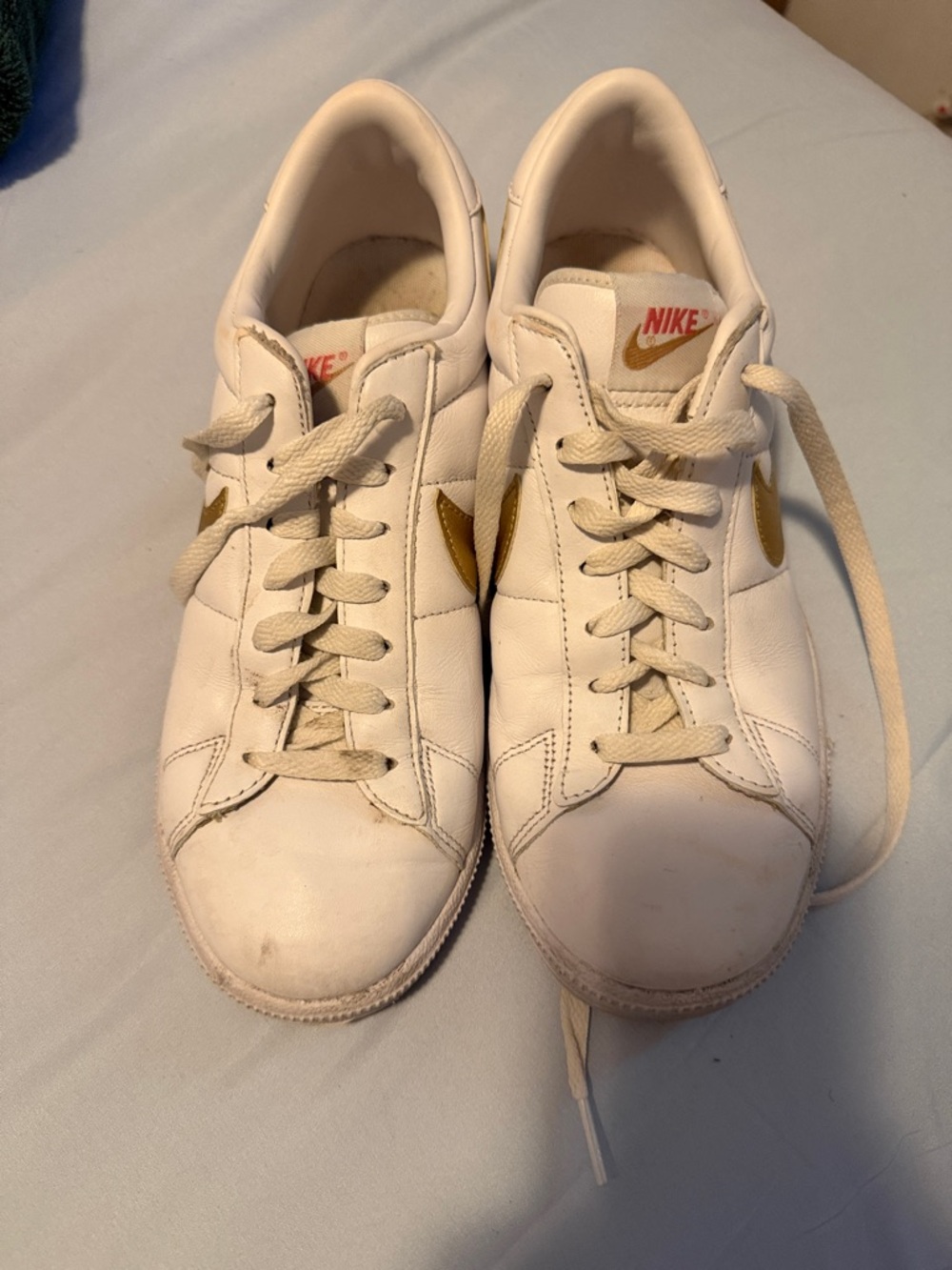 Nike Men’s White Leather Sneakers with Gold Swoosh Accent